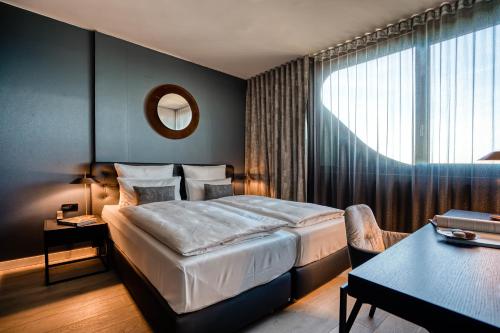 a hotel room with a large bed and a table at CLOUD No7 APARTMENTS in Stuttgart