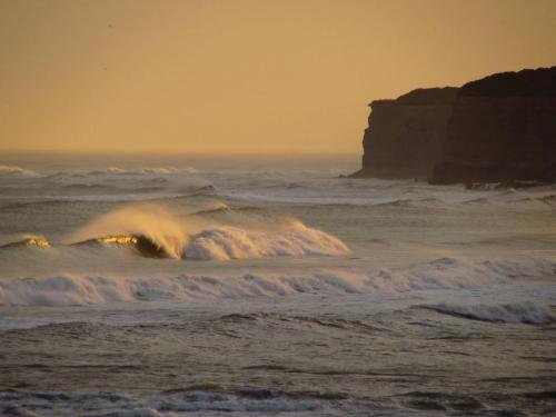 una ola en el océano con un acantilado en el fondo en Ohana! en Mar del Plata