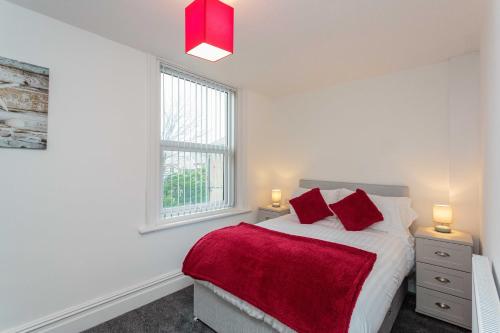 a white bedroom with a bed and two windows at Cherry Property - Berry Apartments in Blackpool