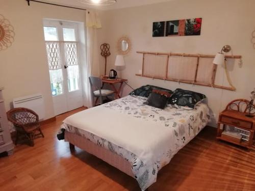 una camera da letto con un letto e un pavimento in legno di La maison de vos vacances a Claret
