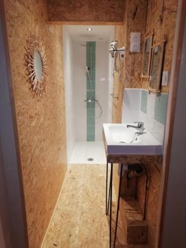 une salle de bain avec un lavabo et une douche avec un lavabo dans l'établissement La maison de vos vacances, à Claret