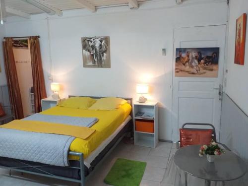 a bedroom with a bed and a table in it at Coco Miel in Les Abymes