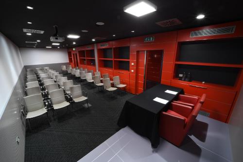 a conference room with red walls and a table and chairs at Best Western Plus Net Tower Hotel Padova in Padova