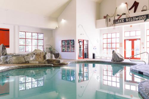 a swimming pool in a building with water in it at Wildwood Lodge & Suites in Clive