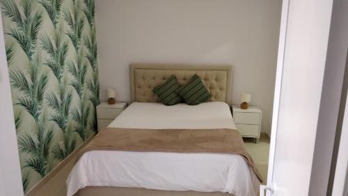 1 dormitorio con 1 cama grande con papel pintado verde y blanco en Praia e Mar 3, en Portimão