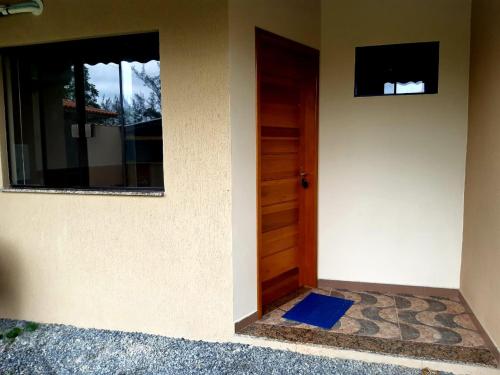 a door to a house with a blue mat next to it at Pousada Ilha Sul in Cananéia