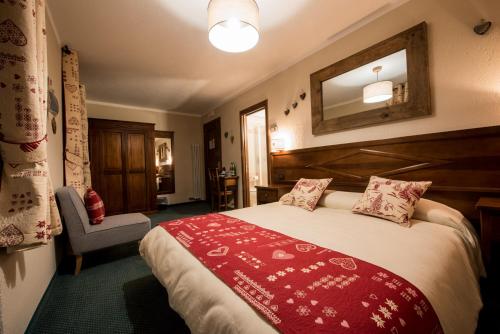 a bedroom with a large bed with a red blanket at Hotel Stella Del Nord in Courmayeur
