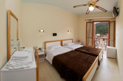 a bedroom with a bed and a desk and a window at Moustakis Hotel in Agia Effimia