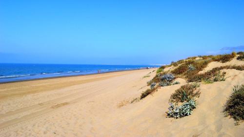 a sandy beach with people in the ocean at LUXURY 3 BEDROOM HOUSE AT LA QUINTA GOLF COURSE OCEAN and MOUNTAIN VIEW in Benahavís