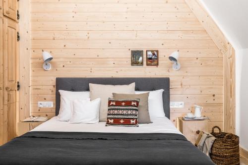 a bedroom with a bed with a wooden wall at Dom Wysoki in Bukowina Tatrzańska