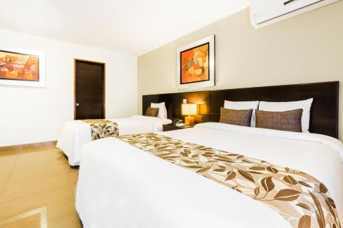 a hotel room with two beds and a couch at El Tambo 1 in Lima