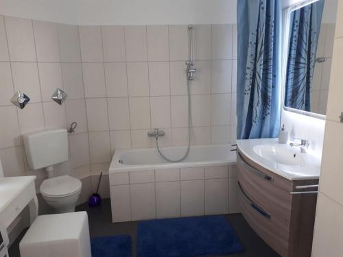 uma casa de banho com um WC, uma banheira e um lavatório. em Pension Altenburg City em Altemburgo