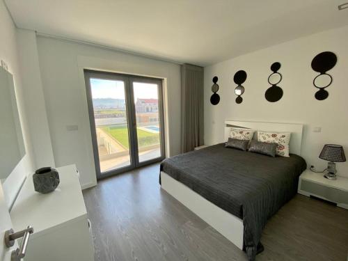 a bedroom with a bed and a large window at SeaHorse House in Esposende