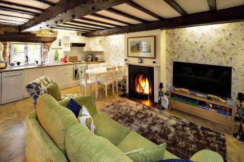 a living room with a couch and a fireplace at River Nene Cottages in Water Newton