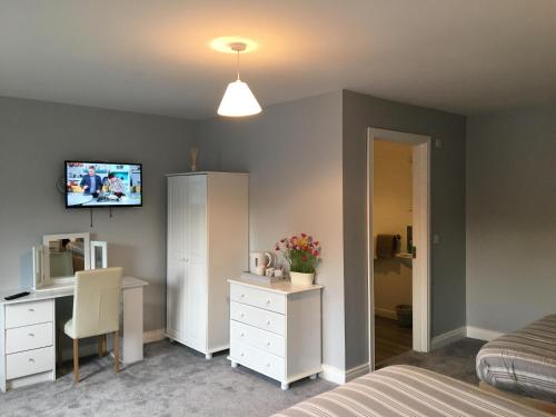 a bedroom with a bed and a desk and a tv at Grangegeeth Inn in Slane