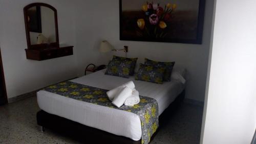 a small bedroom with a bed with a mirror at Hotel Mirador Santana in Anserma