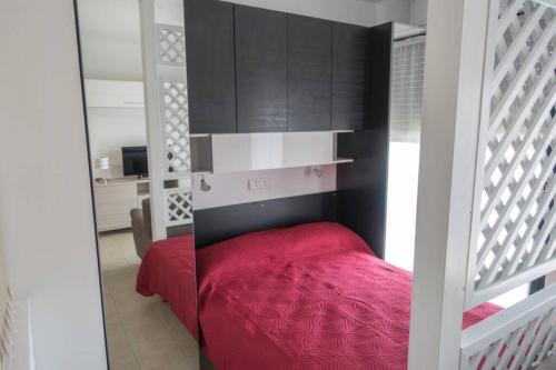 セスト・カレンデにあるApartment Victoria, cozy studio flat near Leonardo Academyの赤いベッドと黒いキャビネット付きのベッドルーム1室