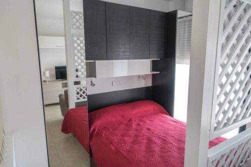 sypialnia z czerwonym łóżkiem i czarnymi szafkami w obiekcie Apartment Victoria, cozy studio flat near Leonardo Academy w mieście Sesto Calende