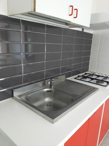 a kitchen with a sink and a stove at Camerota Basic Appartamenti in Lentiscosa