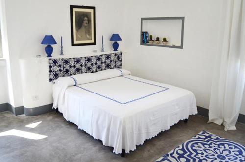 a white bedroom with a bed with a mirror at Masseria Montedoro in Ginosa Marina