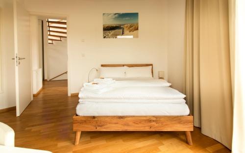 a bedroom with a large bed with white sheets at Quiet Nature Near Cologne 2 in Bergisch Gladbach