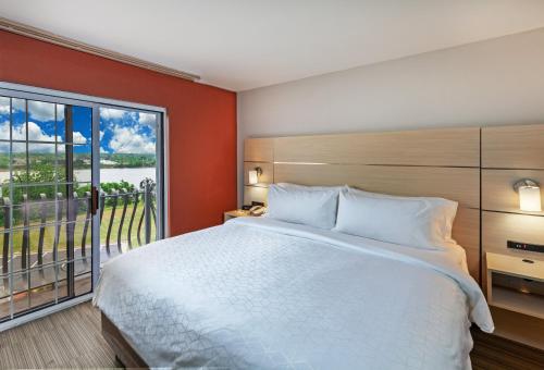 sypialnia z dużym łóżkiem i dużym oknem w obiekcie Holiday Inn Express Hotel and Suites Jenks, an IHG Hotel w mieście Jenks
