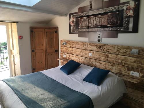 ValaurieにあるLogis Le Mas de Valaurieのベッドルーム1室(木製ヘッドボード付きのベッド1台付)
