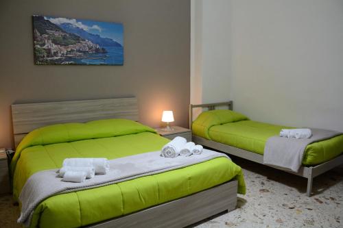 two beds in a hotel room with green beds at Residenza Margherita - Centralissima in Salerno