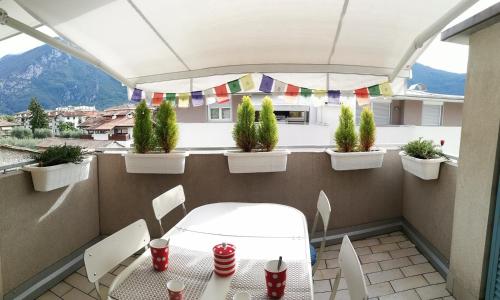 d'un balcon avec une table, des chaises et des plantes en pot. dans l'établissement Appartamento Olea, à Arco