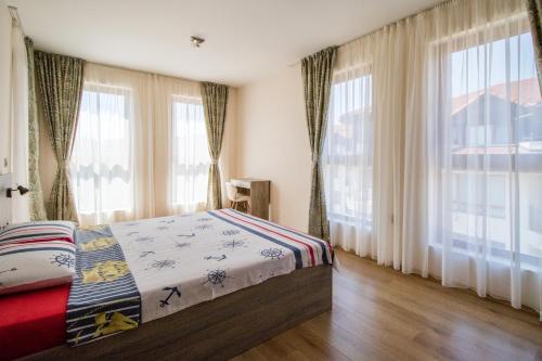 a bedroom with a bed and large windows at Penthouse at White Cliffs in Byala