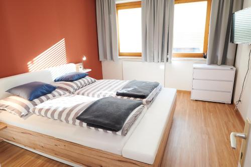 Duas camas num quarto com paredes cor de laranja em Ferienwohnung Klauber Schöder em Schöder