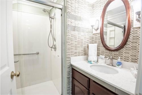 a bathroom with a shower and a sink and a mirror at 309 Water Street Inn in Boyne City