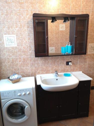 a bathroom with a sink and a washing machine at Appartamento LE DUE ROCCHE in Arona