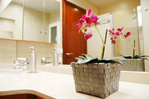 a bathroom sink with a vase with flowers in it at Panier en Osier · Panier en Osier · Charming apartment w/private terrace 2min from sea in Vilassar de Mar