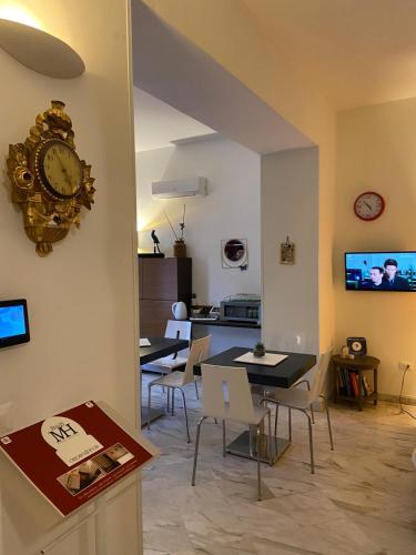 a living room with a table and a clock on the wall at B&B Mini Hotel Incity-close train station and port- in Salerno