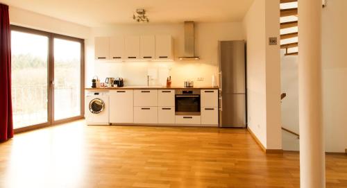 eine Küche mit weißen Geräten und Holzböden in der Unterkunft Quiet Nature Near Cologne 1 in Bergisch Gladbach