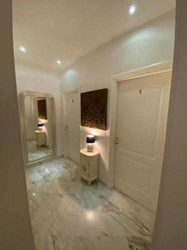 a hallway with a mirror and a table with a lamp at B&B Mini Hotel Incity-close train station and port- in Salerno