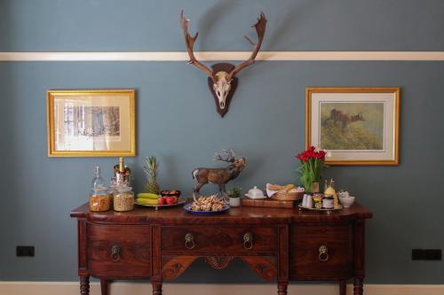 einem Tisch mit Antilopenkopf auf einer blauen Wand in der Unterkunft Gellihaf House in Blackwood