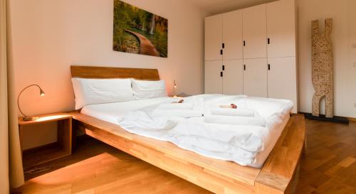 a bedroom with a large white bed with a wooden frame at Quiet Nature Near Cologne 1 in Bergisch Gladbach