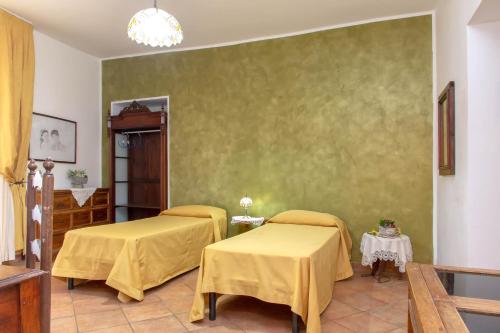 a room with two beds with yellow sheets on it at Donnaciccina Accomodation in Tropea