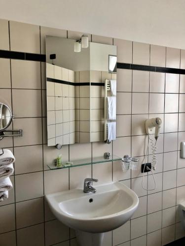 a bathroom with a sink and a mirror at Albavillage Hotel Wellness & Camping in Alba