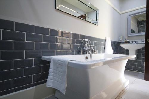 uma casa de banho com uma banheira branca e um lavatório. em Gellihaf House em Blackwood