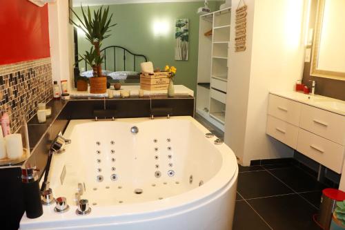 een badkamer met een groot bad en een wastafel bij Suite Melody double balnéo, home-cinéma, terrasse à Dieppe in Dieppe