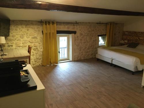 a bedroom with a bed and a room with a window at Le Mas de Valaurie in Valaurie