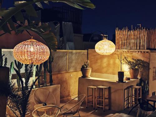 um pátio com uma mesa, cadeiras e luzes em Riad Bamboo Suites & Spa em Marrakech