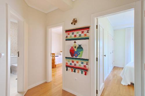 a hallway with a door open to a room with a bathroom at Pool & Tennis Beach House in Praia da Barra