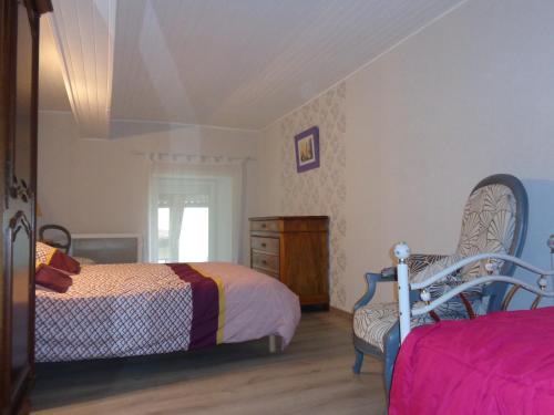 - une chambre avec deux lits et une chaise dans l'établissement 34 Rue de la Coucouroune Gîte de la Coucouroune, à Soual