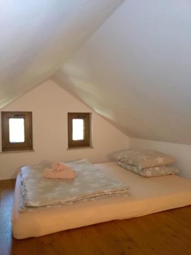 un letto in una stanza con due finestre di Vikendica Vil a Blidinje