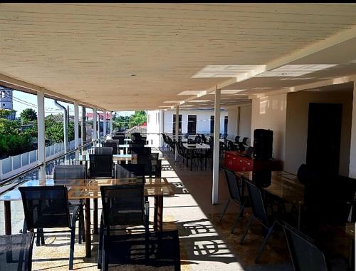 um restaurante vazio com mesas e cadeiras e mesas e cadeiras em Delta Palace em Sulina