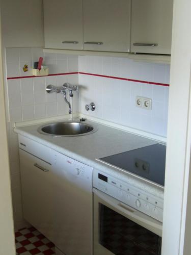 a small kitchen with a sink and a stove at Lütt Baltic Fehmarn in Staberdorf